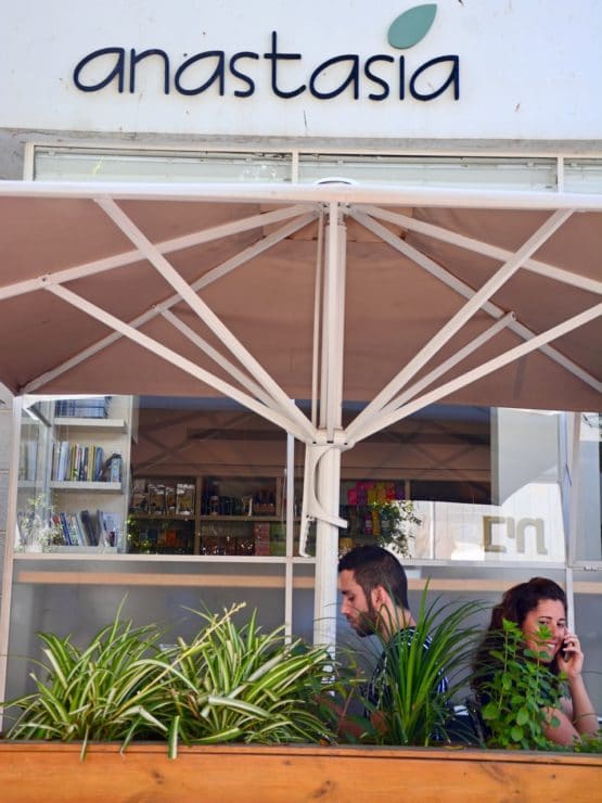 Front of Anastasia restaurant in Tel Aviv, two people dining under outdoor umbrella.