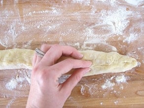 Pinching dough closed around apples.