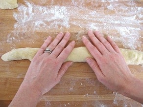 Rolling out log of challah.