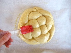 Brushing challah with eggwash.