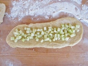 Diced apples spread on challah dough.