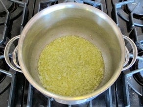 Diced onions sauteeing in a stockpot.