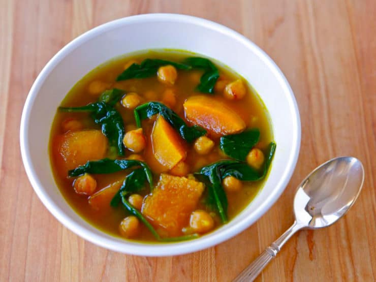 Butternut Squash and Chickpea Soup served on a white bowl with spoon on a table