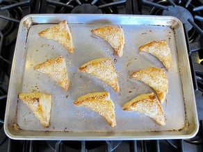 Baked bourekas on a baking sheet.