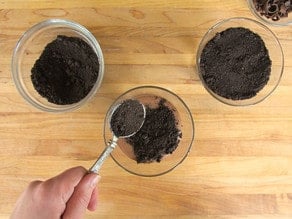 Adding crushed cookies to parfait cups.