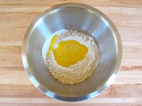 Eggs poured into a well in flour.