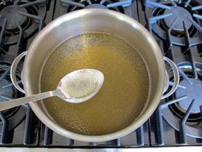 Skimming fat from chicken broth.