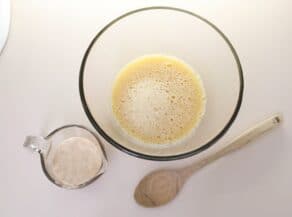 Overhead shot of a bowl of yeast mixed with water and beginning to bubble.