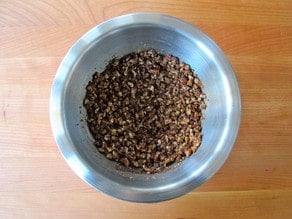 Butter and nuts stirred into brown sugar in a small bowl.