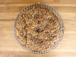 Round cake pan cooling on a rack.