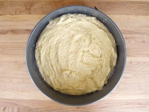 Cake batter spread into a round cake pan.