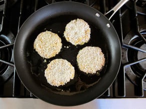 Frying corn schnitzel in a skillet.