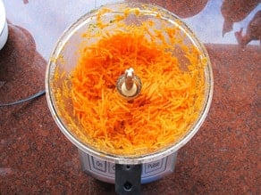 Shredded carrots in a food processor.