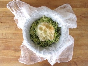 Shredded vegetables in cheesecloth for draining.