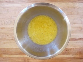 Beaten eggs in a mixing bowl.