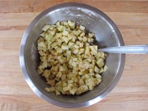 Tossing diced apples in cinnamon sugar.