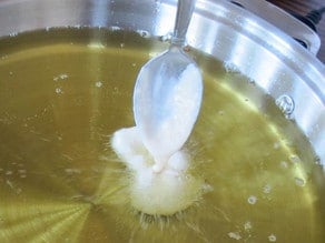 Dropping fritter batter into hot oil to make Hanukkah Fritter Sundaes