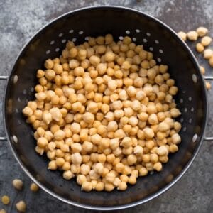 A colander filled with chickpeas on a table