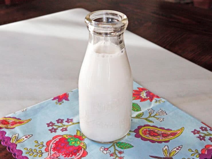 Image of a glass of Cashew Milk resting on a tablecloth