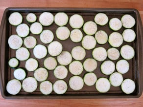 Sliced potatoes on a baking sheet.