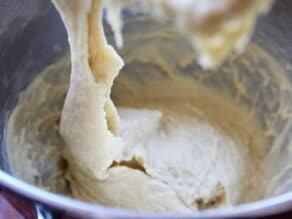 Sticky dough dripping from dough hook in stand mixer.