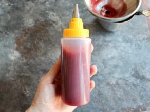 Bottle of strawberry jam with tip for filling sufganiyot.