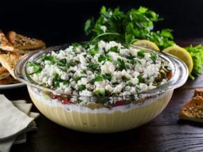 A bowl of Greek dip served with crackers and bread