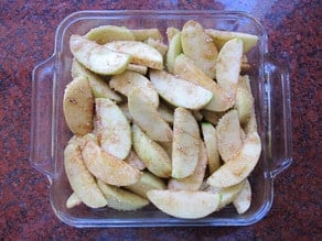 Sliced apples spread in baking dish.