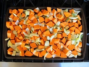 Diced sweet potatoes spread on a baking sheet.