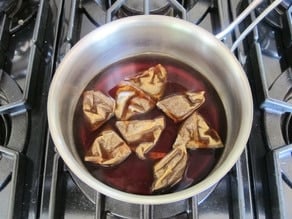 Black tea bags steeping in a pot.