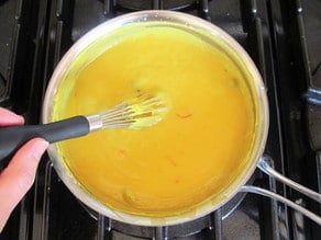 Spices added to coconut milk on stove.