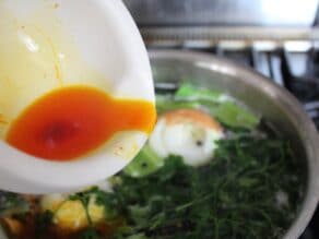 Pouring saffron water into the chicken stock.