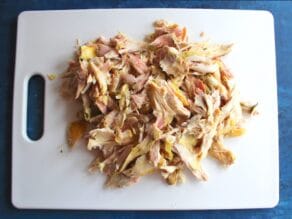 Cutting board with shredded chicken.