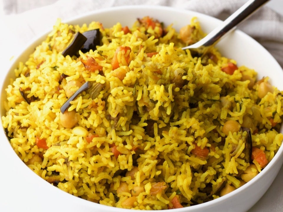 Horizontal Shot - close up of Middle Eastern Roasted Vegetable Rice in a bowl with a spoon.