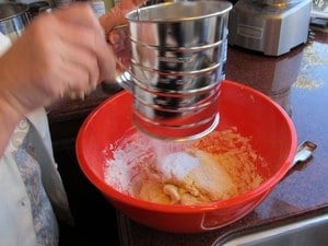 Sifting flour into a mixing bowl.