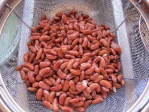 Kidney beans with water being drained on the sink