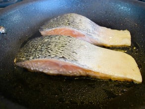 Closeup of salmon searing.