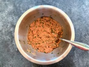 Turkey burger mixture in a mixing bowl with fork.