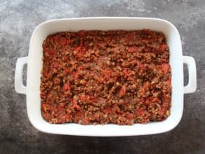 Lentil pepper and mushroom filling in 2 quart casserole dish on concrete surface.