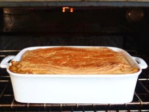 Hummus Roasted Vegetable Moussaka beneath broiler in oven.