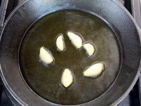 Whole garlic cloves in hot oil in small cast iron skillet, lightly sizzling.