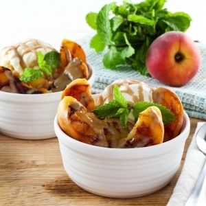 Grilled Peach Sundae with Brandy Butterscotch Sauce - Recipe for grilled ripe peaches and creamy caramelized sauce over vanilla frozen yogurt. 