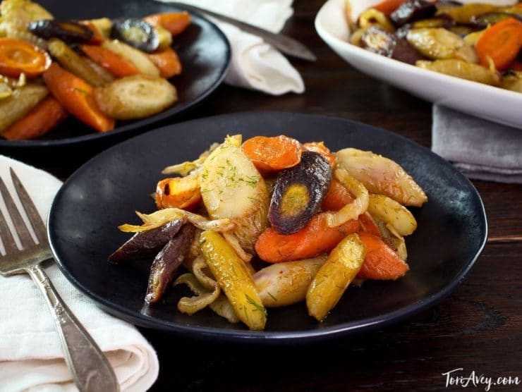 A plate of Spicy Roasted Carrots and Fennel, accompanied by a medley of vegetables including carrots and onions