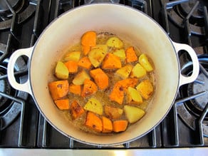 Frying diced potatoes in a Dutch oven.