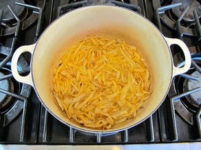 Simmering onions in chicken stock.