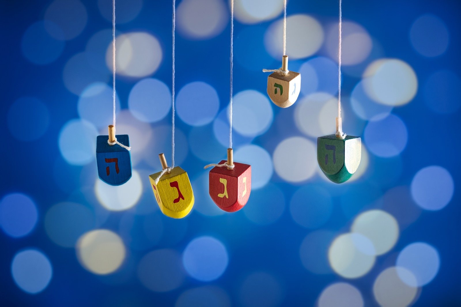 Colorful Hanukah designs on wooden items tied on a string