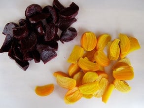 Roasted, peeled, diced beets on a cutting board.