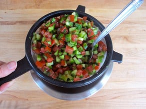 Making sure all liquid is strained from cucumbers and tomatoes.