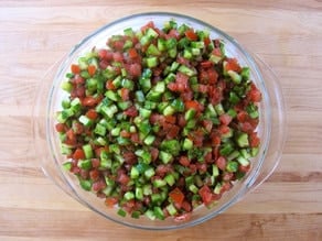 Cucumbers and tomatoes adding to serving bowl.