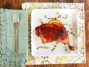 A plate of succulent chicken leg coated in a sweet and tangy date glaze